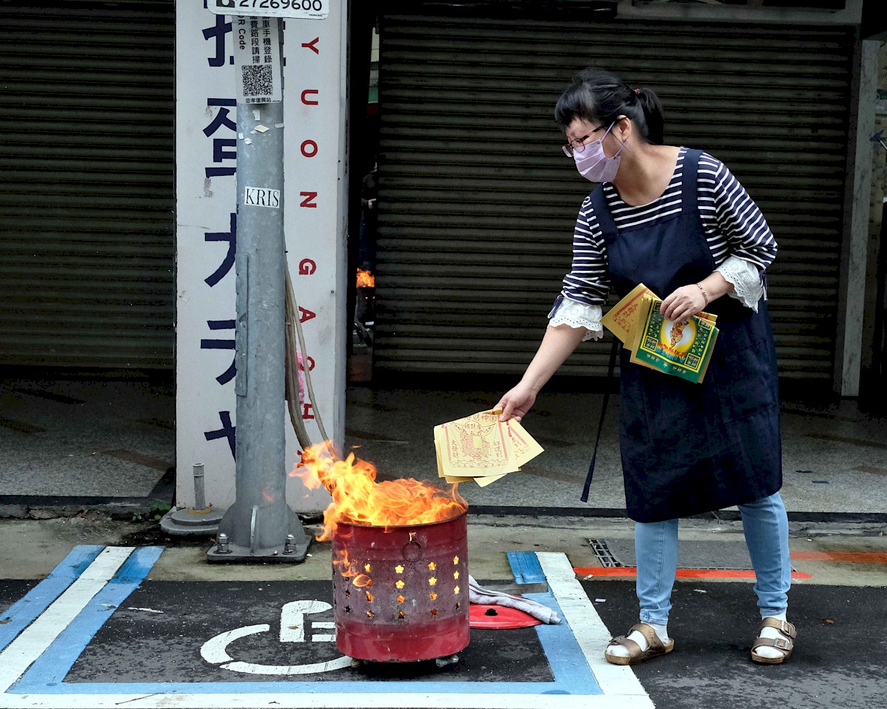 Burning joss paper on parking spots for the disabled during Hungry Ghost Festival